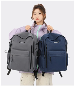 Detail of grey and navy nylon travel backpacks featuring large front pockets and dual zippers