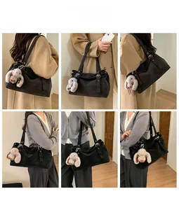 Detail view of large black corduroy tote bag with silver buckle and plush bunny charm