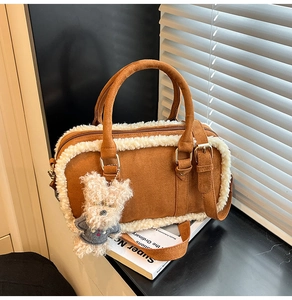 Détail du sac en daim caramel avec bordure en peau lainée blanche et breloque ours