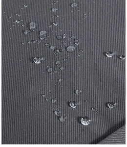 Detail shot of water-resistant dark grey twill fabric with droplets on the surface