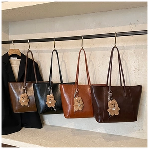 Detail view of large tote bags in four colors hanging with cute bear charms