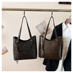 Detail of vintage faux leather tote bags in black and coffee with adjustable shoulder straps
