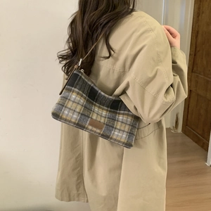Vue détaillée de la texture du sac cabas à carreaux et de la bandoulière en cuir