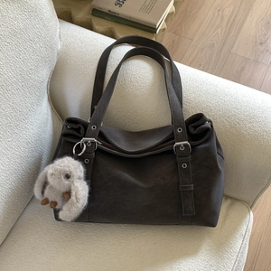 Retro dark coffee tote bag on a white bouclé sofa with a cute plush rabbit charm