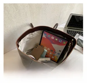 Top view of retro brown tote bag interior with multiple compartments and daily items