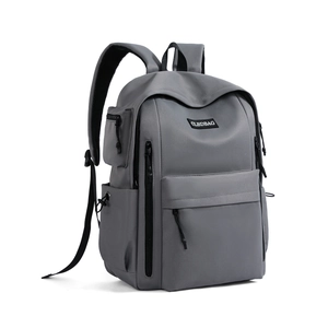 Detail of grey travel backpack showing waterproof fabric, side zipper, and brand patch