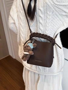 Dark brown pebbled leather bucket bag with woven handle and cute bear charm pendant