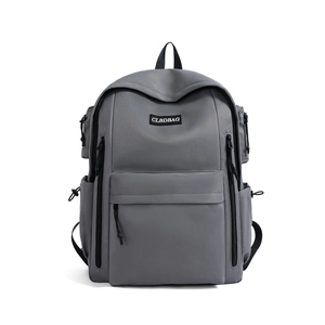 Front detail of dark grey travel backpack with multi-pocket design and woven label