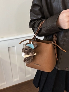 Brown litchi leather bucket bag with chain strap and teddy bear charm accessory