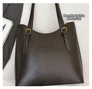 Detail view of premium coffee brown PU leather texture and gold hardware on tote bag