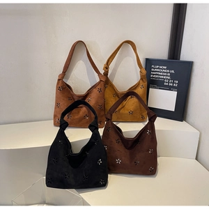 Detailed view of four bohemian tote bags with laser-cut floral patterns and knotted handles