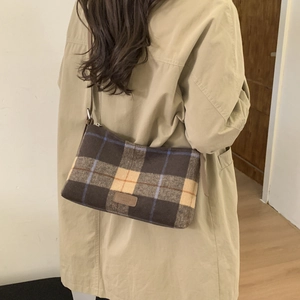 Sac fourre-tout à carreaux marron et bleu en laine porté à l'épaule pour l'hiver