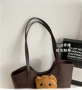 Detailansicht der braunen Ledershoppingbag mit Plüschbärenanhänger und robustem Handgriff