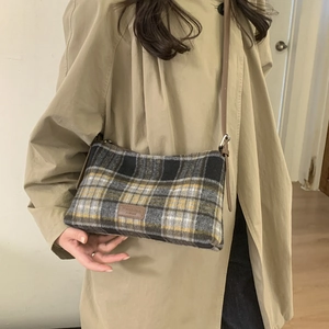 Détail du sac cabas en tweed à carreaux jaune et noir avec bandoulière en cuir