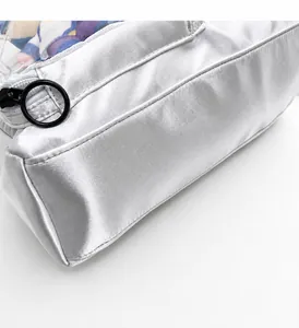Detail view of silver satin storage bag featuring a black round zipper and clear window
