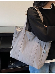Light grey nylon tote bag with large capacity and logo shown on a fashion model