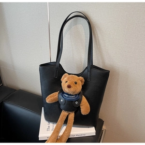 Detailansicht der schwarzen Tote-Bag aus Leder mit einem süßen Bären-Plüschanhänger