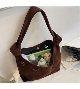 Spacious interior of dark brown suede hobo bag holding a bottle, umbrella and tablet