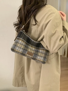 Sac cabas à carreaux classique avec anses en cuir marron porté avec un trench-coat beige