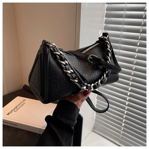 Detail of black lychee grain leather handbag with chunky silver chain and strap