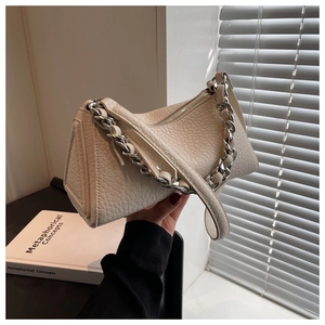 Detail of creamy white leather underarm bag with silver chain and litchi texture