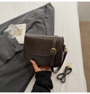 Detailed close-up of dark brown leather handbag texture with gold hardware accents