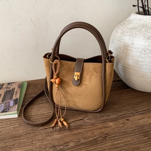 Gros plan du sac fourre-tout rétro en daim marron avec lanières en cuir et perles en bois