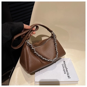 Detailed shot of brown litchi grain leather bag with chic silver chain and side profile