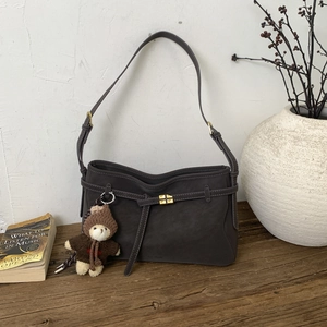 Retro large grey matte leather tote bag with gold lock and plush bear on wood surface