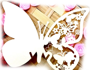 Laser-cut white butterfly place cards with heart patterns for wedding table decorations