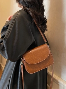 Vintage brown leather crossbody saddle bag with matte finish shown on model