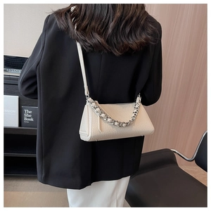 Close-up of beige lychee leather shoulder bag with chunky silver chain detail