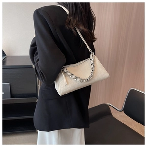 Detail view of cream shoulder bag with lychee texture leather and silver chain strap