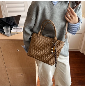 Detail of caramel woven texture tote bag with wooden beads and adjustable strap