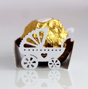 Macro detail of laser-cut baby carriage candy box accessory with white paper lace