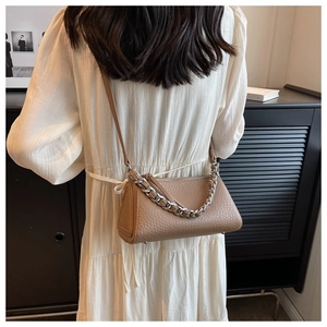 Detail of light brown lychee textured leather shoulder bag with chunky silver chain link