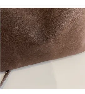 Détail d'un sac cabas en cuir marron grainé avec logo doré et texture raffinée
