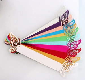 Macro detail of laser-cut butterfly napkin rings in various shiny metallic paper colors
