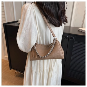 Close-up of brown pebbled leather shoulder bag with a stylish chunky silver chain detail