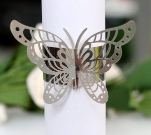 Macro view of silver butterfly napkin ring with laser-cut hollow pattern and polished finish