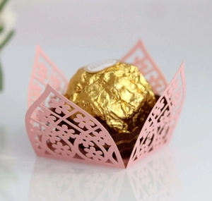 Detailed laser-cut pink floral cupcake wrapper featuring intricate hollow patterns for parties