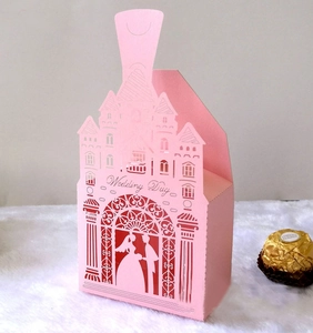 Detail of laser-cut pink wedding favor box with castle silhouette and romantic engraving