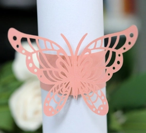 Makro-Detail des pfirsichfarbenen Serviettenrings mit feinen Laser-Cut-Blumenmustern