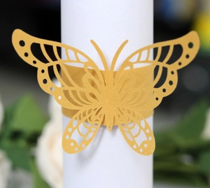 Close-up of golden butterfly laser-cut napkin ring with intricate wing patterns