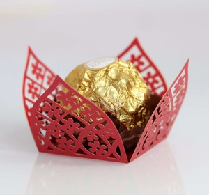 Macro detail of red laser-cut floral hollow paper wrapper for chocolate and wedding sweets