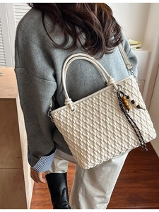 Minimalist beige quilted bucket bag with woven tassel and detachable shoulder strap