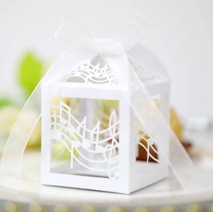 Close-up of white laser-cut candy box with musical notes and decorative ribbon bow