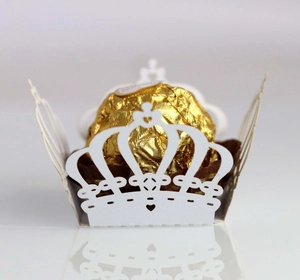 Macro view of white crown-shaped laser-cut favor box with intricate heart hollow patterns