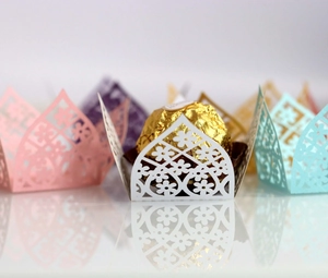 Macro shot of laser-cut hollow lace design wrappers for wedding chocolates and candies