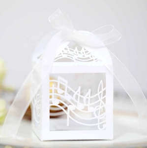 Close-up of laser-cut musical note candy box with white organza ribbon bow